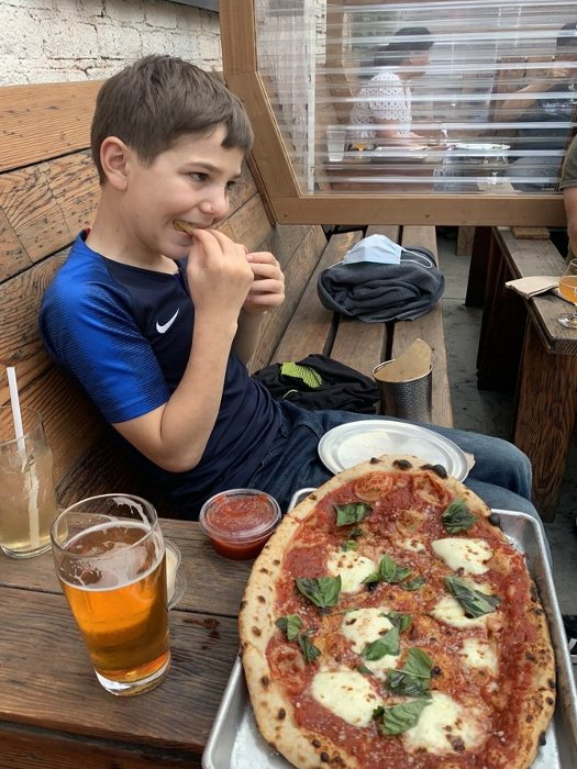 Child eating pizza at Drake's Dealership in Oakland