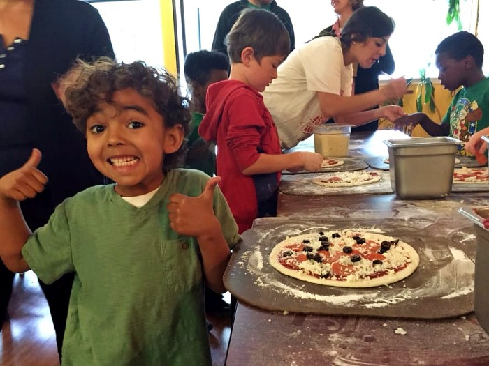 Kids help make pizzas at Red Boy pizza in Oakland