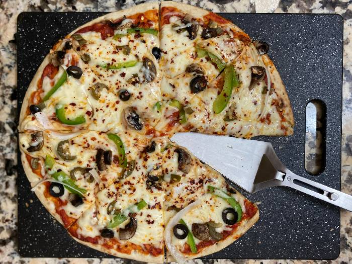 Pizza cut into slices on a countertop