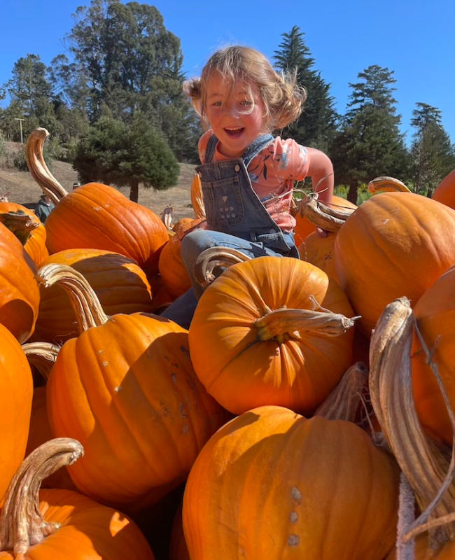 kid on a pumpkin pile
