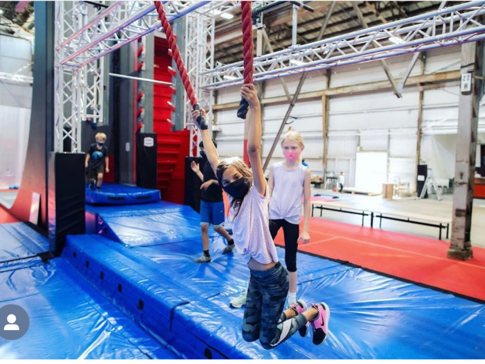 kids hanging from ropes on obstacle course