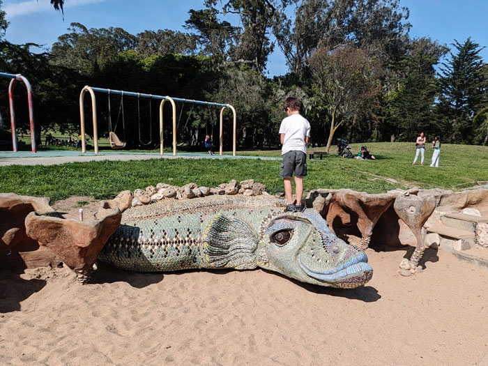 child climbs on a dragon sculpture