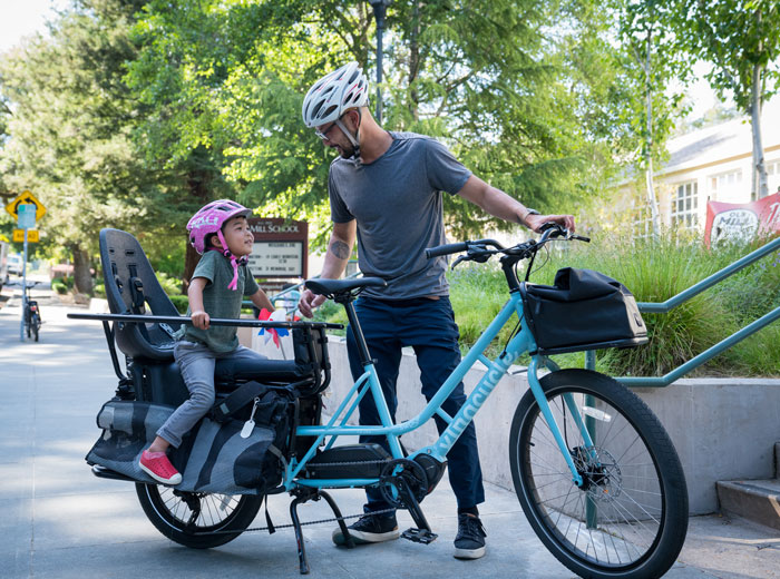Dad and daughter riding bike to school