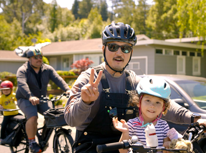 Dad and child riding bike together and posing