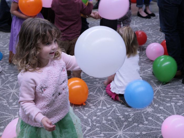 child enjoying a room full of balloons