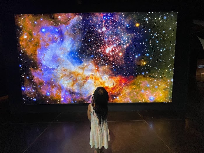 child looking at photo of deep space