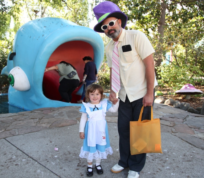 child and parent in halloween costumes in front of whale
