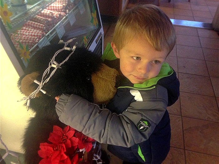 Child hugging stuffed bear at BearClaw Bakery in Pinole