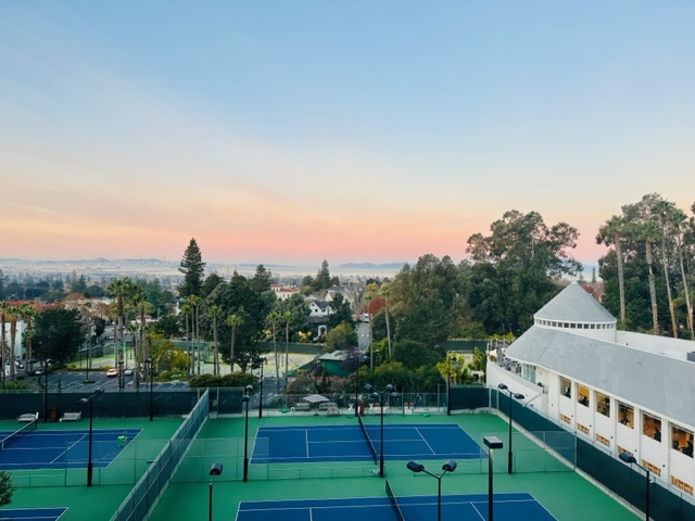 view of tennis courts and bay