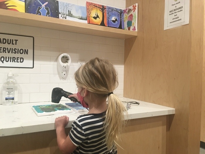 Child at art drying station
