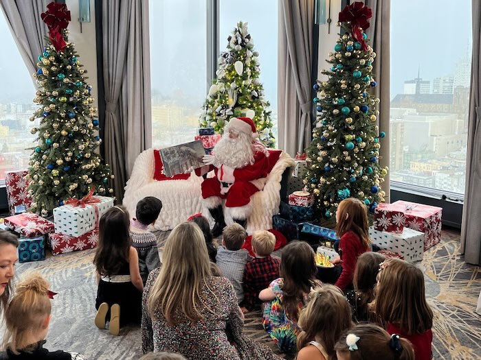 santa claus reading a story book to children