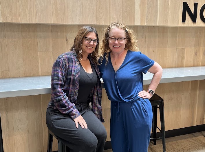 two women at public market standing and leaning