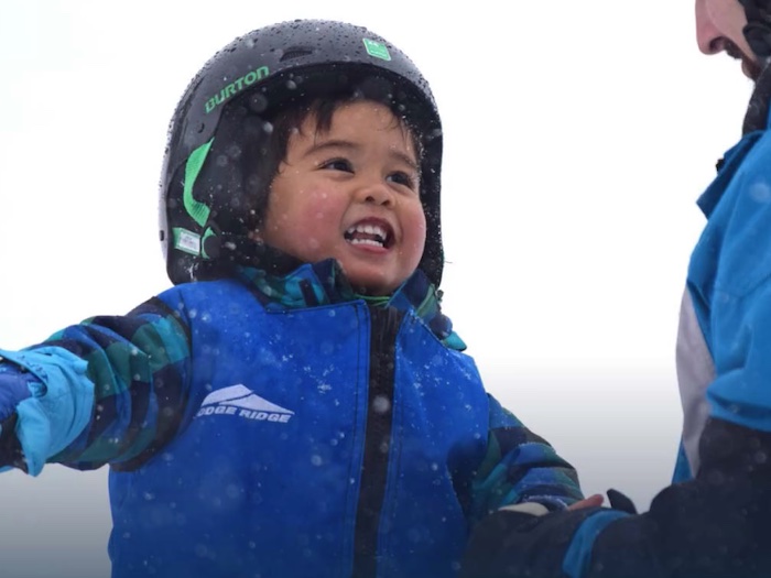 little kid in ski gear with an instructor