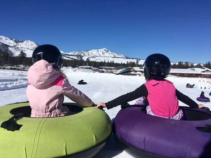 Children on snow tubes in mountains