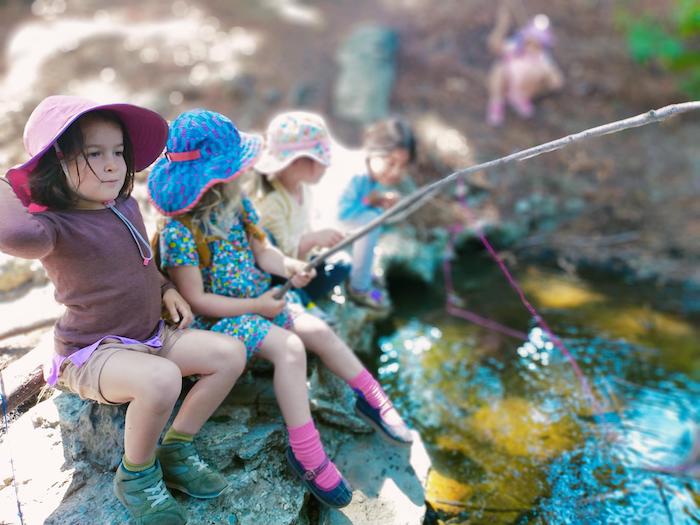 children fishing in a creek