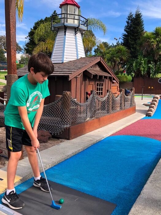 Boy playing at Golden Tee Golfland Mini Golf