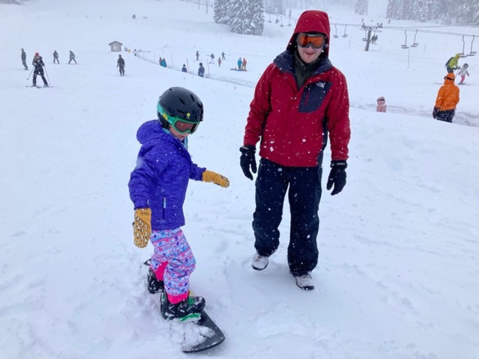 Child learns to snowboard