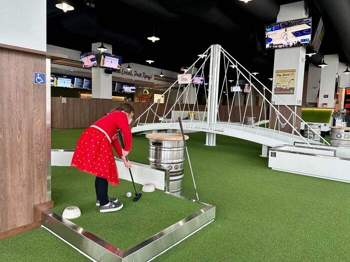 Best Mini Golf Courses in East Bay and Beyond 2 Toddler plays at indoor mini golf with bridge design in background