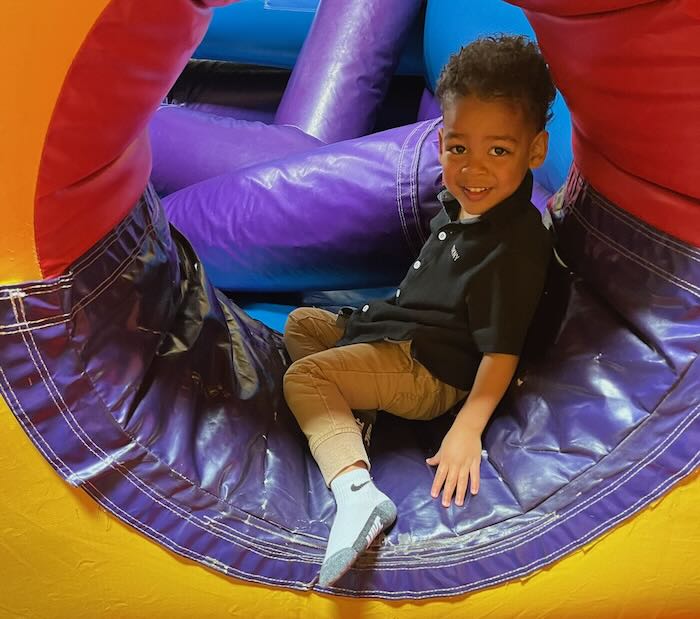 child crawling through a tunnel made of soft play foam