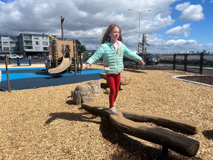 Child on balance beam at playground