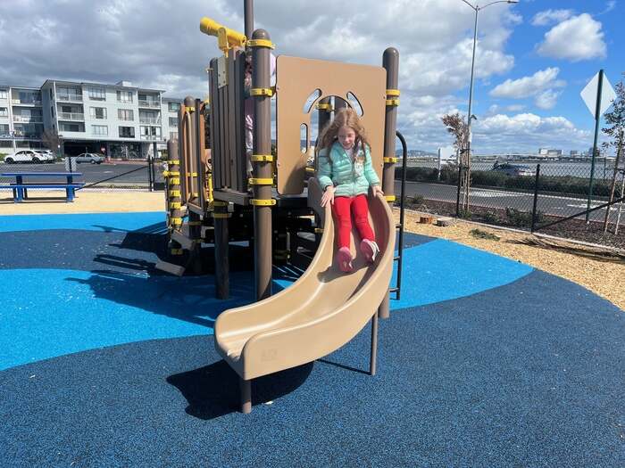 Child going down slide at playground in emeryville