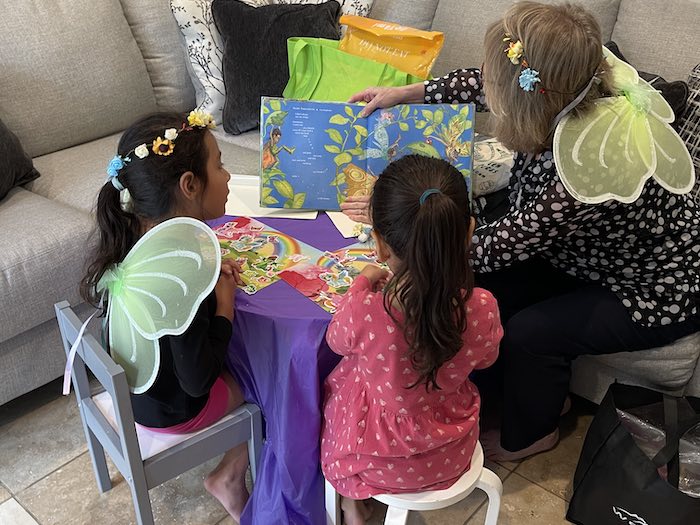 Grasshopper Kids: Win the Best Playdate Ever 2 adult and 2 children reading a story wearing fairy wings