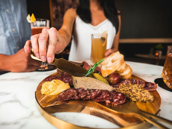 two people sharing a charcuterie board