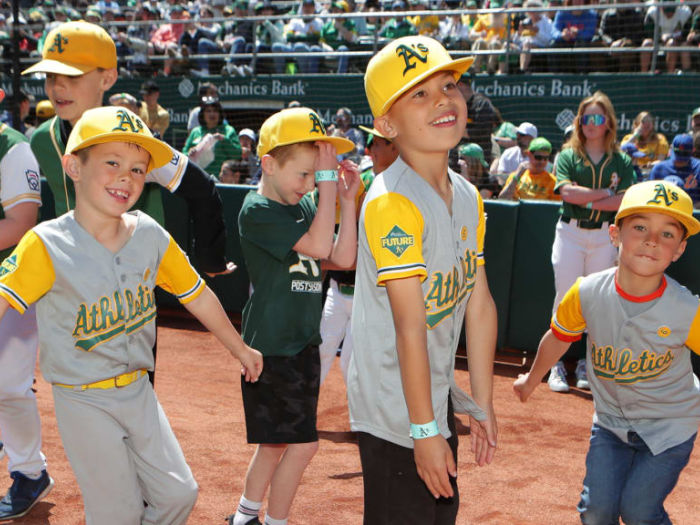 Young fans on the field at an Oakland A's game