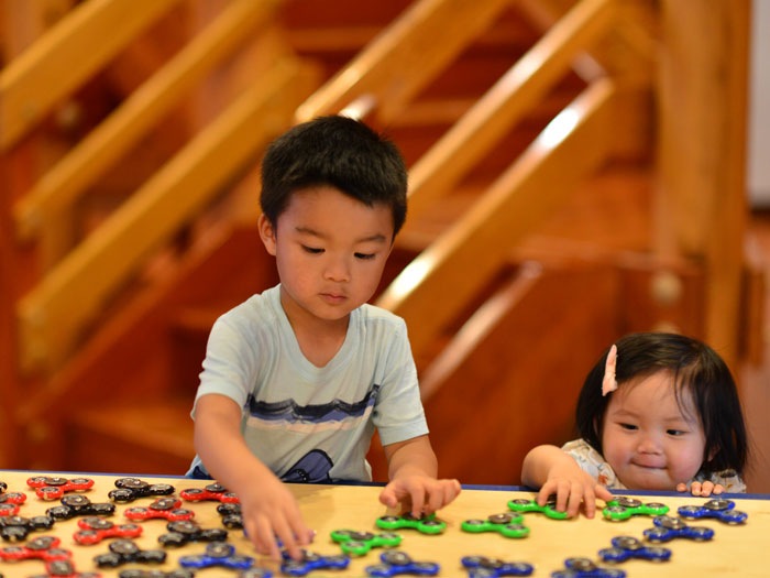 toddlers playing with gears on a table