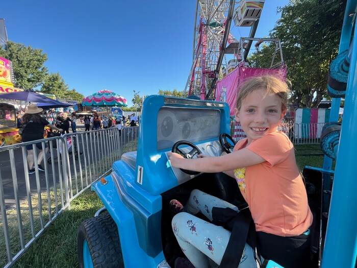 Child on car-themed carnival game