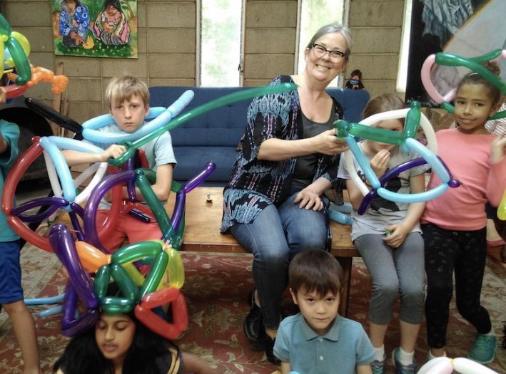 Firecracker Math Camp kids and teacher making balloon shapes together