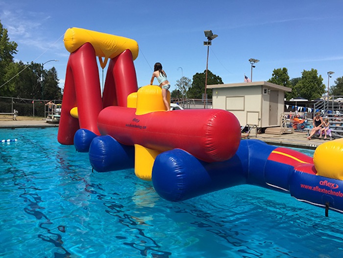 girl on floating obstacle course in a swimming pool, Clarke Memorial Swim Center