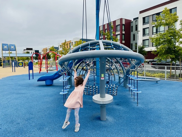 child swinging on play structure