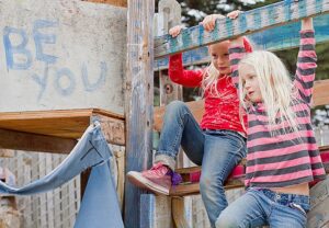 two girls in a hand made play structure