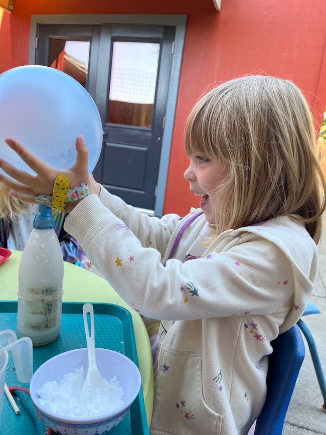 young child doing science experiment on playground