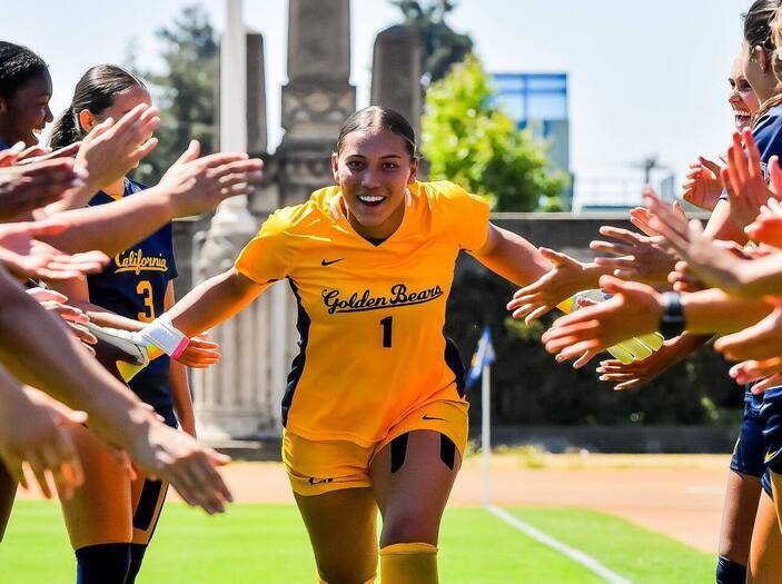 Soccer athlete high fives teammates