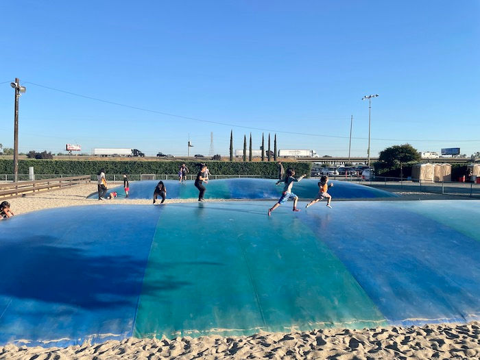 a blue bouncy pillow with children running around