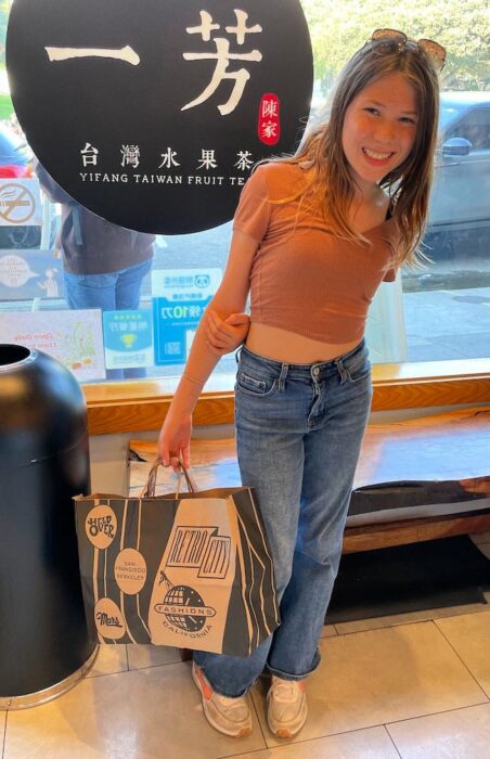 tween holding thrift shopping bags at yifang boba shop