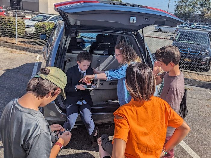 kid eating a cupcake out of the back of a minivan