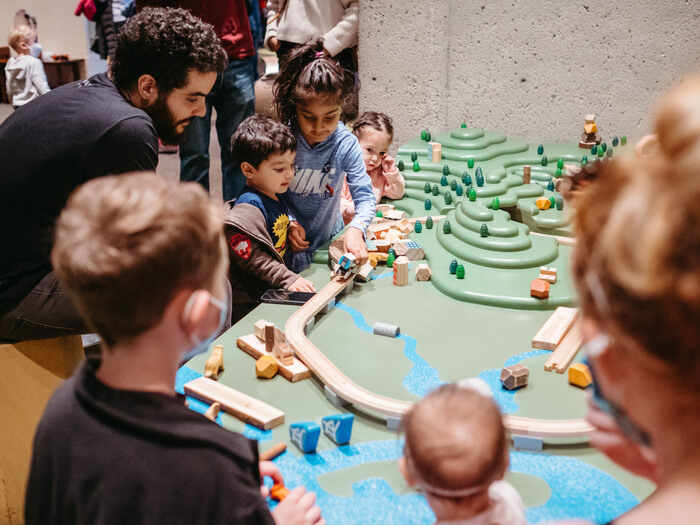 Family playing at train table at OMCA Kids Nature Playspace