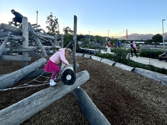 Girl climbs on nature playground