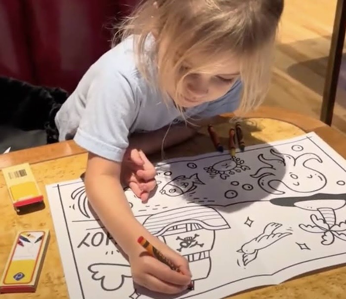 child with coloring placemat at a restaurant