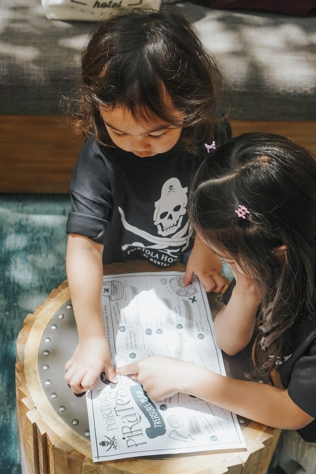 two kids study treasure map