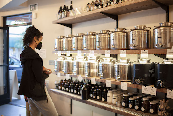 Re-Up Refill Shop cooking oils section and a woman