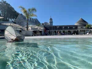 small child floating in a wide open swimming pool