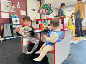 toddler and preschooler sitting in a pretend diner