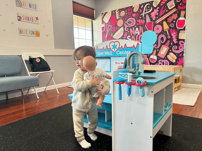 toddler play area baby with a baby doll playing doctor