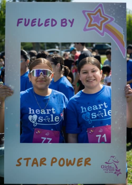 two girls holding frame cutout