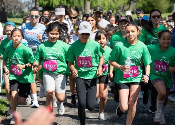 girls with green shirts running in a race