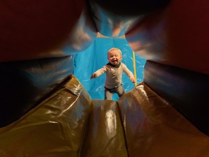 small child playing hide and seek in the bouncy obstacle course